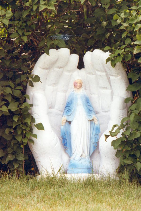 Statue de sainte-vierge dans une grotte en forme de mains
